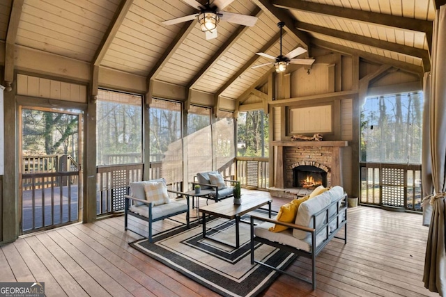 sunroom / solarium featuring ceiling fan, vaulted ceiling with beams, plenty of natural light, and wooden ceiling