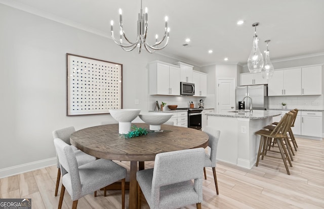 dining space featuring a chandelier, crown molding, and light hardwood / wood-style floors