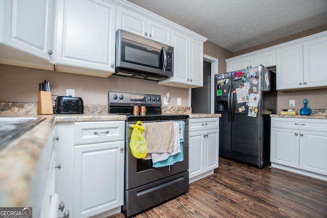 kitchen with light stone counters, a textured ceiling, stainless steel appliances, dark hardwood / wood-style flooring, and white cabinets