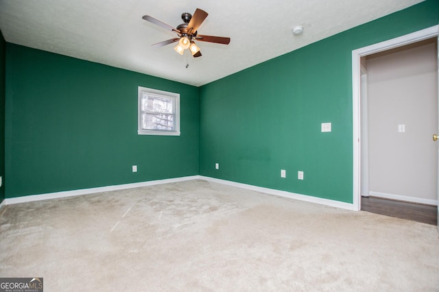 carpeted spare room featuring ceiling fan