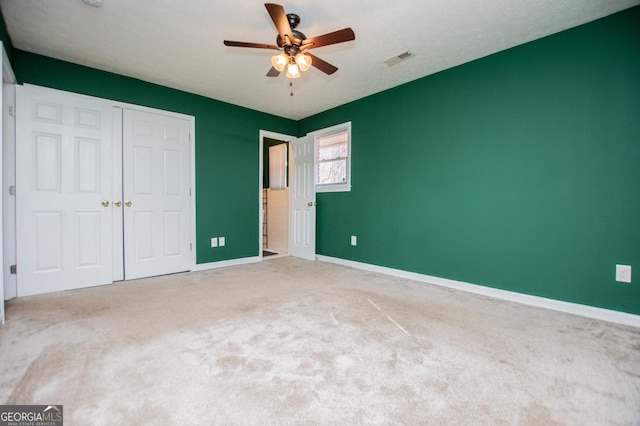 unfurnished bedroom with a closet, ceiling fan, and carpet flooring