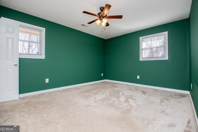 carpeted spare room featuring ceiling fan