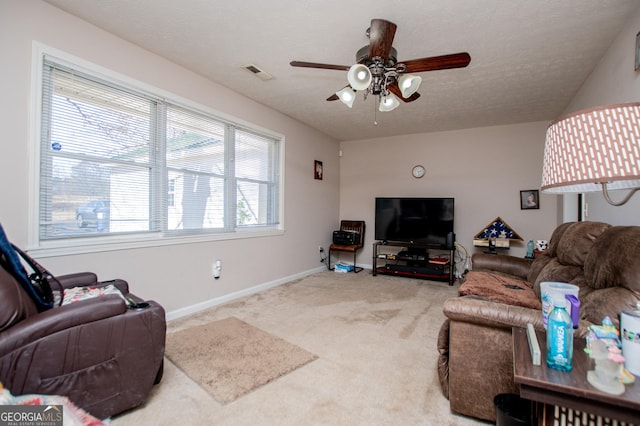 living room with ceiling fan, carpet, and a textured ceiling