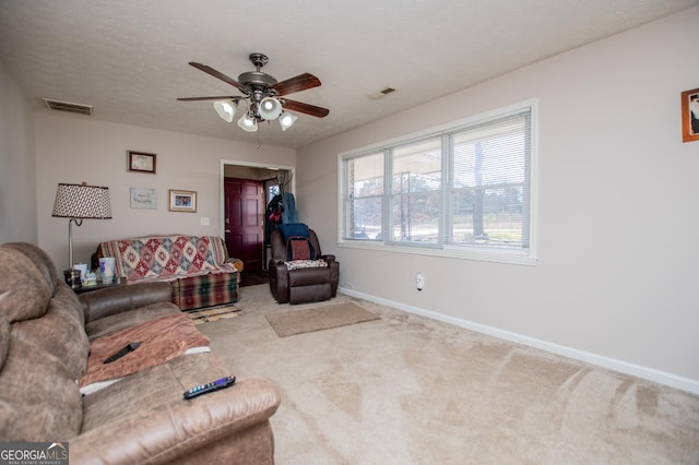 living room with ceiling fan, carpet, and a textured ceiling