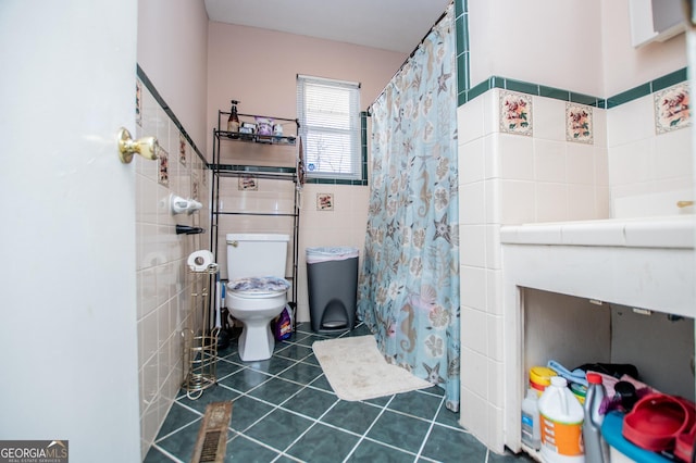 bathroom featuring tile walls, toilet, tile patterned floors, and walk in shower