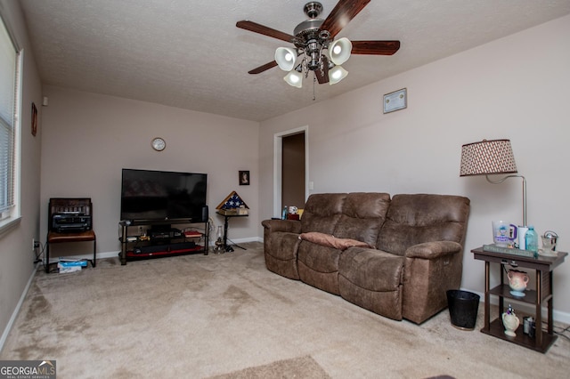 living room featuring carpet floors, a textured ceiling, and ceiling fan