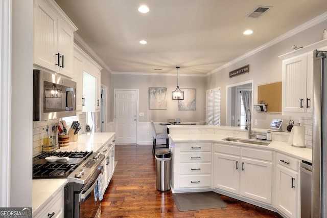 kitchen with white cabinets, kitchen peninsula, sink, and stainless steel appliances