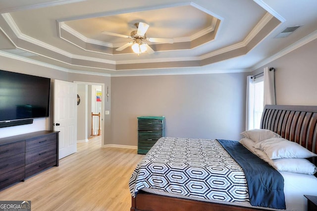 bedroom featuring a raised ceiling, ceiling fan, ornamental molding, and light hardwood / wood-style flooring