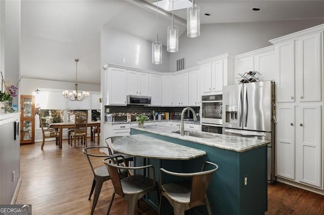 kitchen with white cabinets, backsplash, sink, and stainless steel appliances