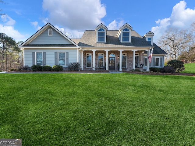 cape cod-style house featuring a front yard and a porch