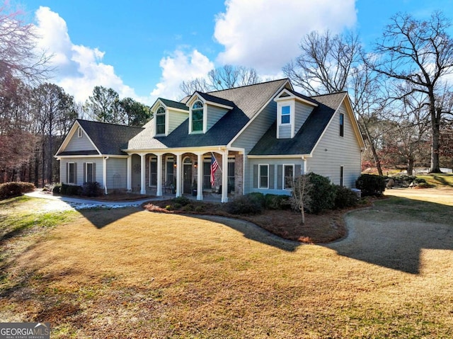 new england style home with a porch and a front yard