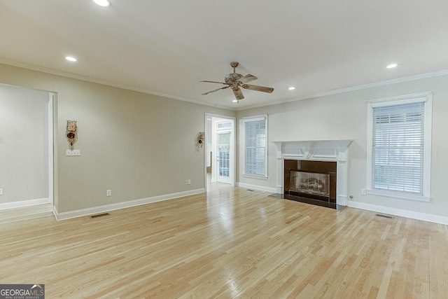 unfurnished living room with ceiling fan, light wood-type flooring, and crown molding