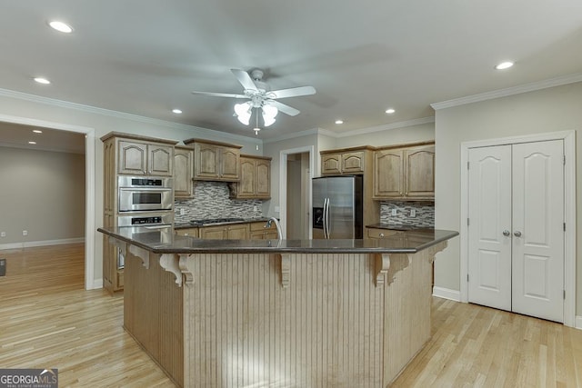 kitchen with a kitchen bar, stainless steel appliances, a kitchen island, and tasteful backsplash