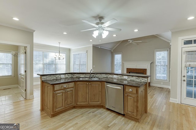 kitchen featuring a center island with sink, backsplash, decorative light fixtures, dishwasher, and sink