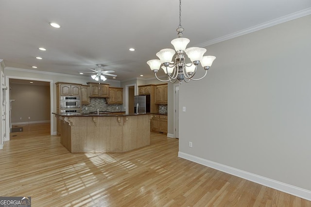 kitchen with pendant lighting, a kitchen island, stainless steel appliances, tasteful backsplash, and light wood-type flooring