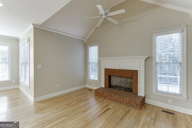 unfurnished living room with ceiling fan, vaulted ceiling, a fireplace, and ornamental molding