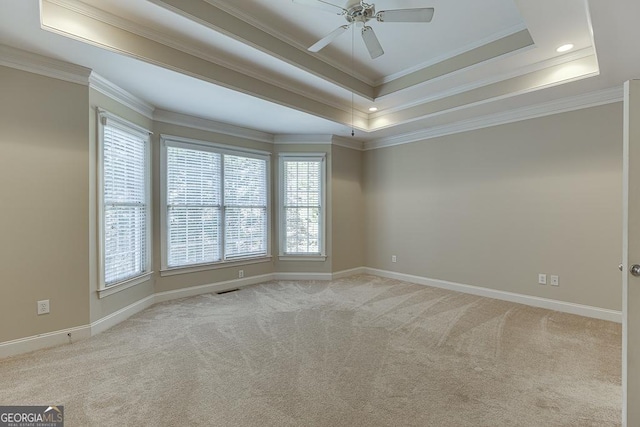 carpeted empty room with crown molding, ceiling fan, and a tray ceiling