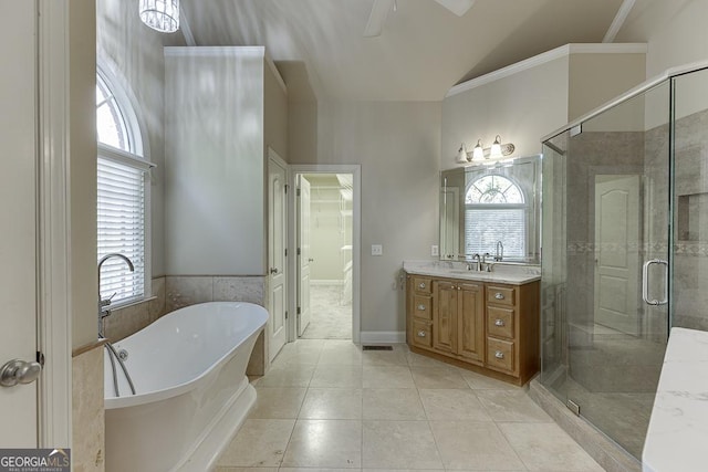 bathroom featuring plus walk in shower, vanity, lofted ceiling, and tile patterned flooring