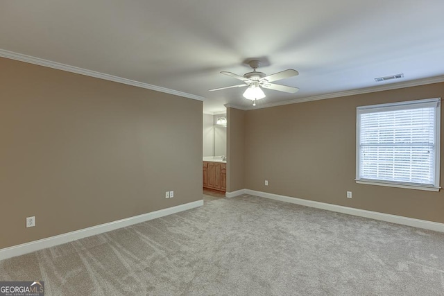 carpeted spare room with ceiling fan and crown molding