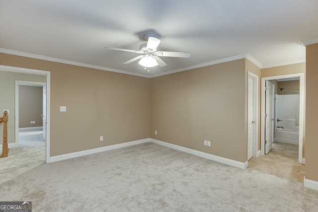 carpeted spare room featuring ceiling fan and crown molding