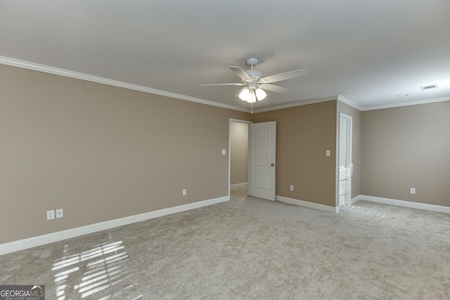 carpeted spare room featuring ceiling fan and crown molding