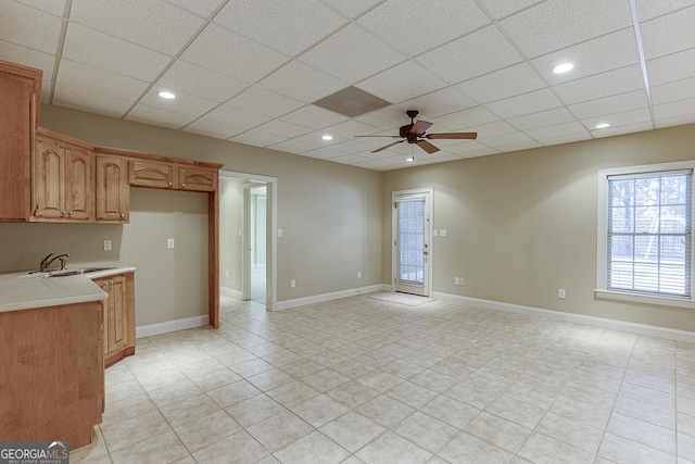 kitchen with ceiling fan, sink, and a drop ceiling