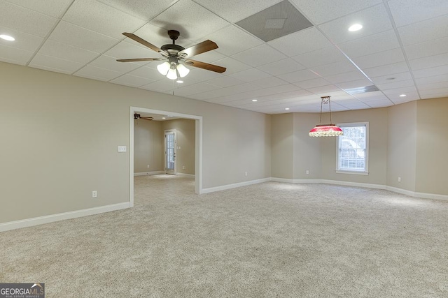 spare room with ceiling fan, a paneled ceiling, and carpet