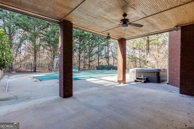 view of patio with ceiling fan and a hot tub