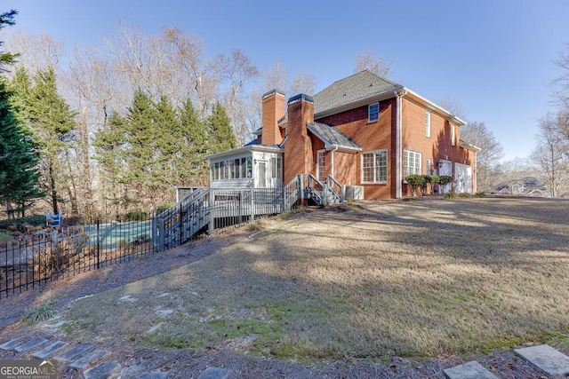 rear view of property with a garage and a sunroom