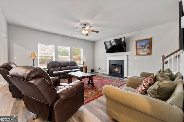 living room with ceiling fan and light wood-type flooring