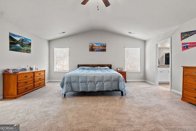 bedroom with ceiling fan, light carpet, ensuite bathroom, and multiple windows