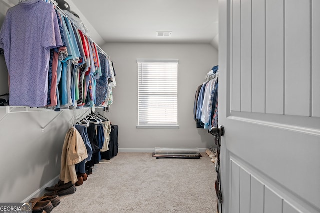 walk in closet featuring light carpet and lofted ceiling