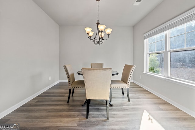 dining room with wood-type flooring and a chandelier