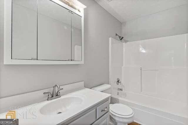 full bathroom with washtub / shower combination, toilet, and vanity