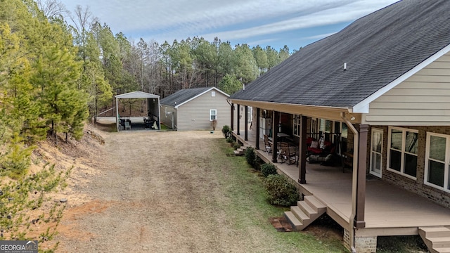 view of yard with a wooden deck and a carport