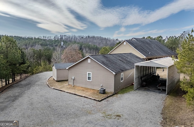 view of property exterior with central air condition unit and a storage shed