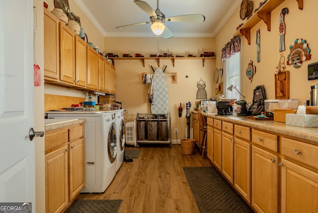 laundry area featuring washer and dryer, light hardwood / wood-style floors, cabinets, and ornamental molding