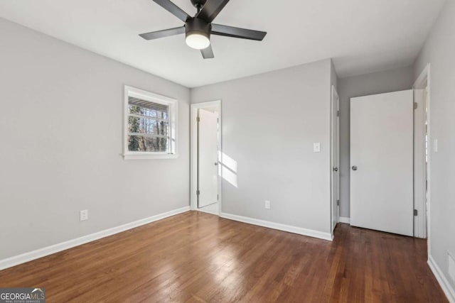 unfurnished bedroom featuring ceiling fan and dark hardwood / wood-style floors