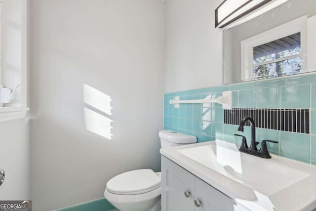 bathroom with toilet, tile walls, and vanity