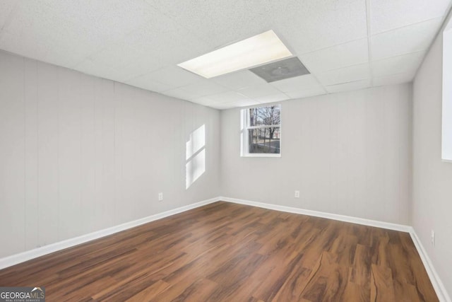 unfurnished room featuring a drop ceiling and dark hardwood / wood-style flooring