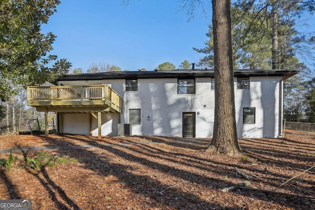 rear view of property featuring central AC and a wooden deck