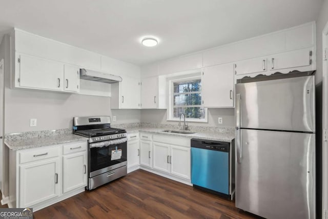 kitchen with dark wood-type flooring, stainless steel appliances, white cabinetry, and sink