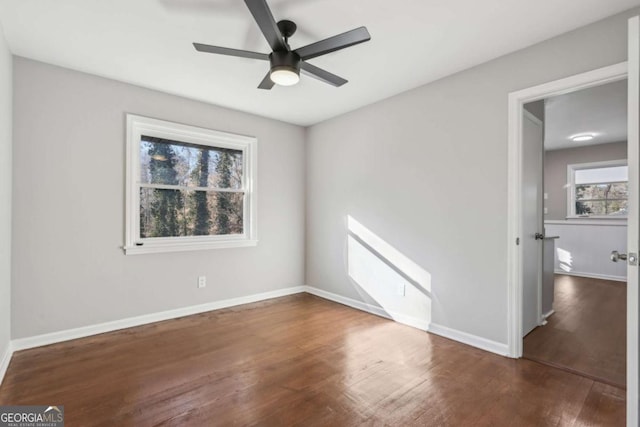 empty room with ceiling fan and dark hardwood / wood-style floors