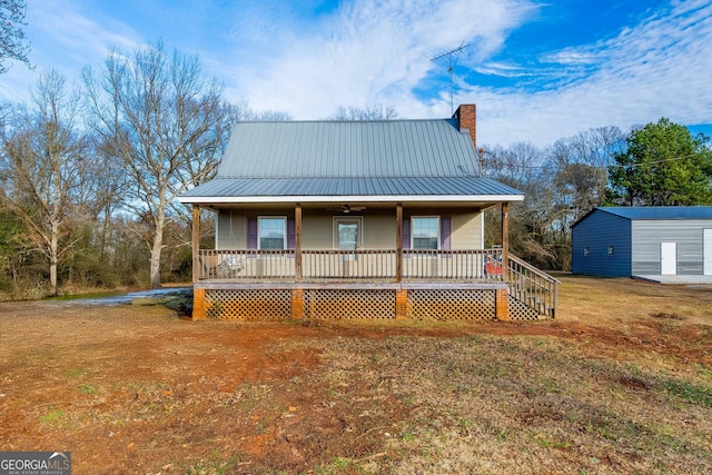 view of front of house with a front lawn, an outdoor structure, and a porch