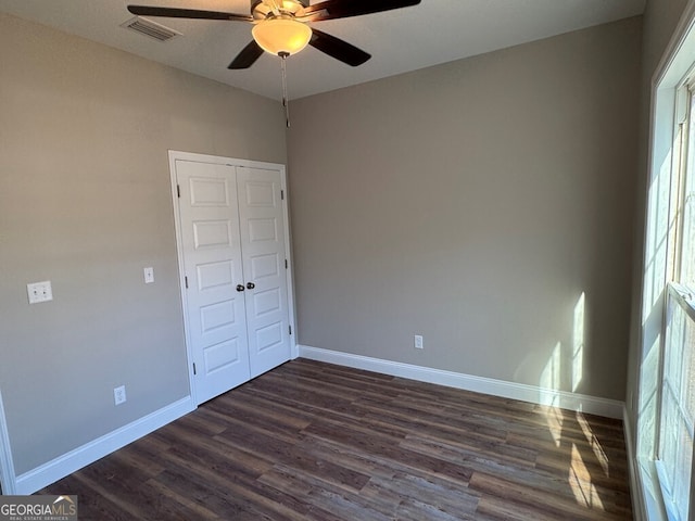 empty room featuring ceiling fan and dark wood-type flooring