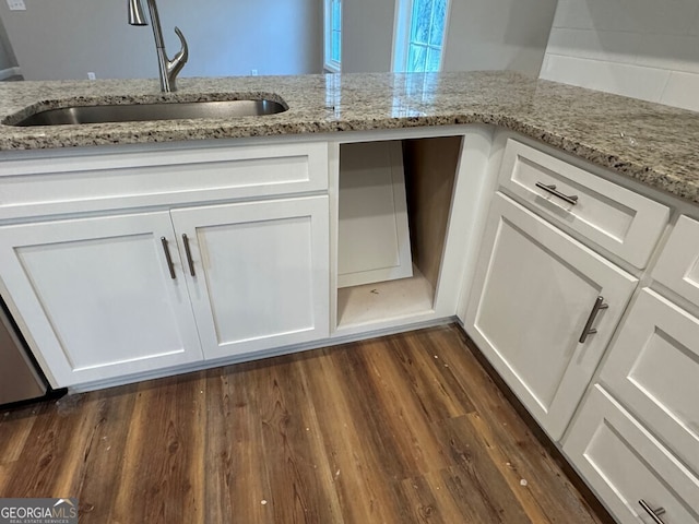 kitchen featuring light stone countertops, sink, and white cabinetry