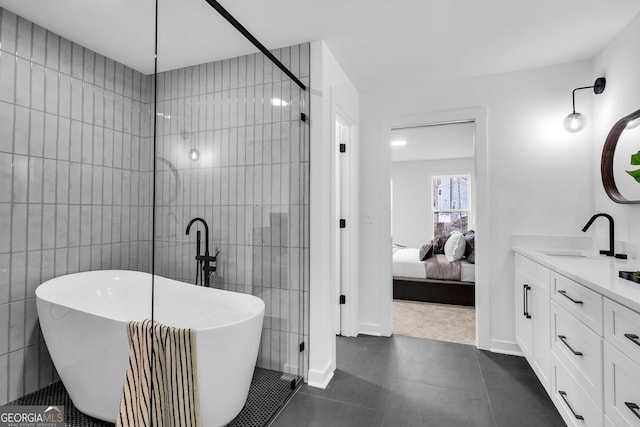 bathroom with a washtub, vanity, and tile patterned floors