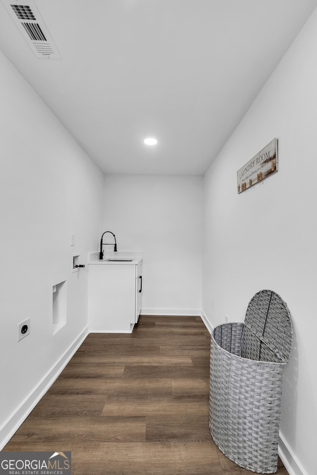 laundry area featuring sink, hookup for a washing machine, dark hardwood / wood-style floors, cabinets, and hookup for an electric dryer