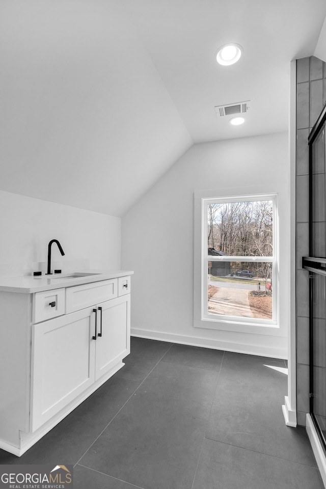 bonus room with sink and vaulted ceiling