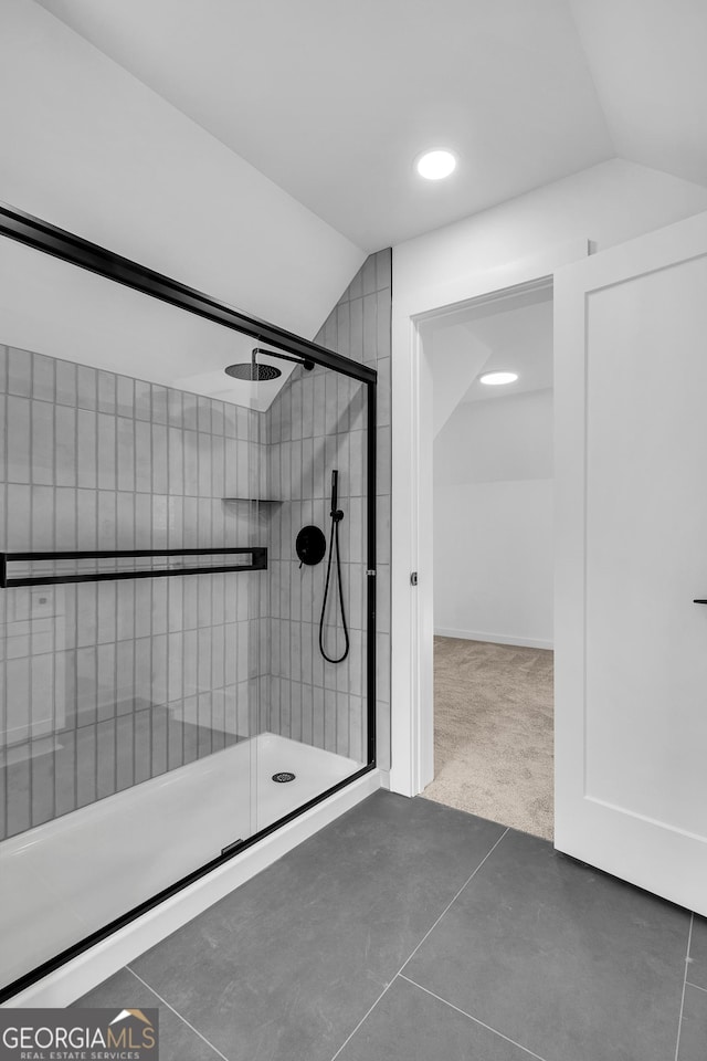 bathroom featuring a shower with shower door and vaulted ceiling